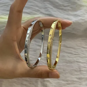 Close-up detail of double-color rhinestone pave bangles featuring elegant geometric metal design.