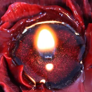 Candela profumata artigianale peonia rossa con effetto cera glitterata e fiamma romantica vista principale.