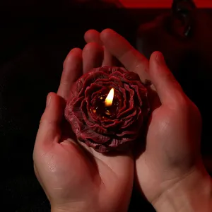 Red rose scented candle for romantic couples ambiance, dark red petal design burning wick.
