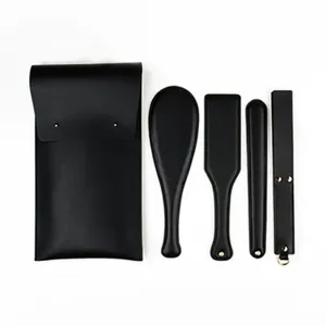 Black leather BDSM spanking paddle whip set with storage bag for adult practice use.