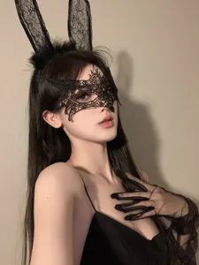 Detailed shot of black lace bunny ears headband and intricate hollow eye mask costume accessory.