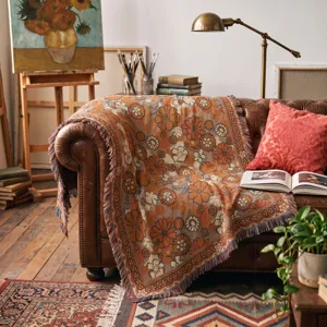 Close-up of Bohemian floral woven throw blanket with fringe on a vintage leather sofa