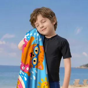 Kind mit buntem Mikrofaser Strandtuch mit Katzenmotiv am sonnigen Meeresstrand