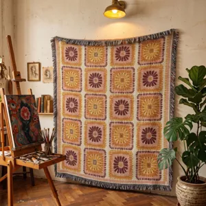 Woven bohemian blanket with floral sunburst pattern hung as wall decor in an art studio.