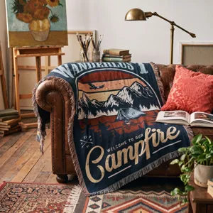 Detailed texture of a woven Wanderlust camping throw blanket on a vintage leather sofa