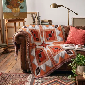 Bohemian geometric woven throw blanket with fringe detail for outdoor and home decor.