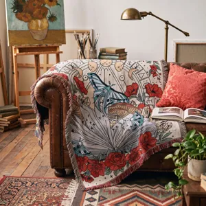 Close-up of bohemian woven throw blanket with butterfly and rose pattern on leather sofa