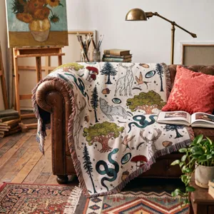 Detailansicht der gewebten Boho-Decke mit Waldtier-Motiven und bunten Fransen auf Sofa