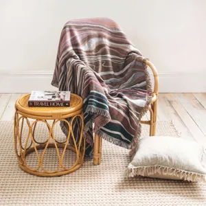Detail view of a Bohemian woven throw blanket with colorful fringes on a chair