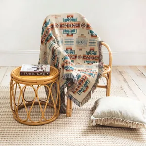 Close-up of bohemian tribal pattern woven throw blanket with fringe edges on chair