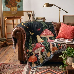Detailed view of a woven mushroom pattern throw blanket draped on a vintage leather sofa.