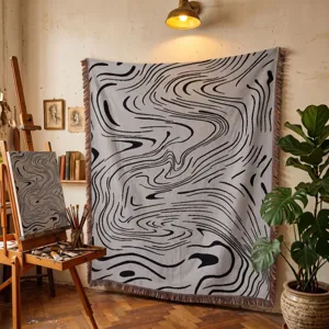 Jeté de lit gris artistique avec motifs abstraits noirs dans un décor de studio d'artiste