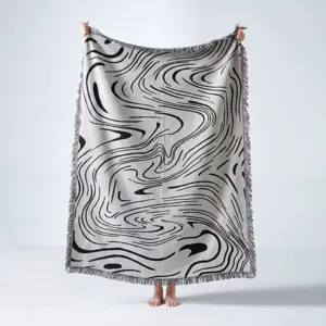Détail de la couverture de camping bohème avec motifs de vagues noirs et blancs
