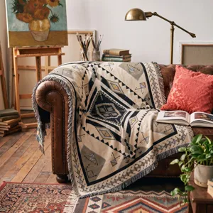 Close-up of a bohemian woven throw blanket with tassels on a vintage leather sofa