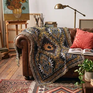 Detail of Bohemian woven throw blanket with sun pattern on a vintage leather sofa.