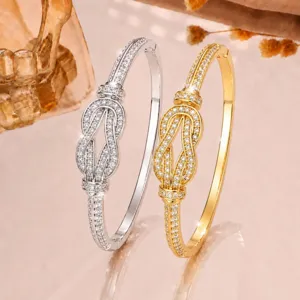 Exquisite micro-paved cubic zirconia infinity knot cuff bracelets in gold and silver finish.