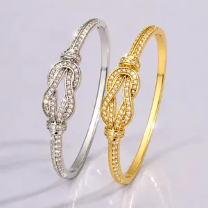 Detailed shot of the elegant infinity knot crystal rhinestone bangle bracelet in silver and gold.