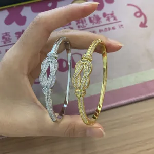 Detail shot of elegant double-color pave rhinestone knot metal bangles for women gift.
