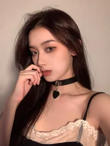 Black heart choker necklace detail shot, stylish gothic neck jewelry for women and girls.
