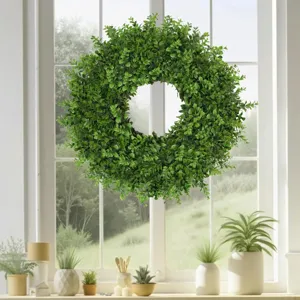 Macro detail of artificial boxwood wreath greenery hanging in front of a bright sunny window