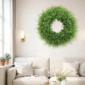 Large artificial green boxwood wreath hanging on a white wall in a modern living room