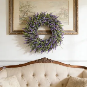 Vibrant purple lavender wreath hanging elegantly on a white wall above a vintage sofa