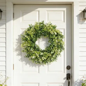 Kunstmatige buxus en veldbloemen krans op een klassieke witte houten voordeur geplaatst