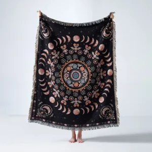Couverture bohème tissée avec phases de lune et mandala tenue dans un studio