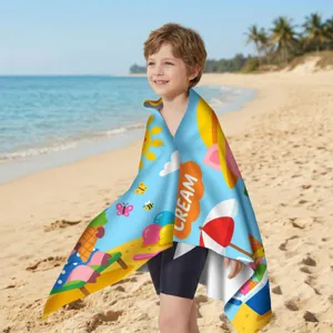 Kind trägt ein buntes Mikrofaser-Strandtuch mit Sommermotiven an einem sonnigen Strandtag
