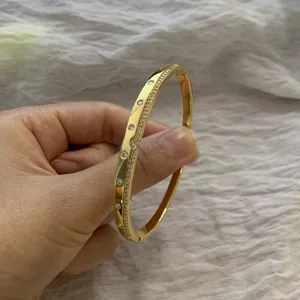 Gold pave diamond detail wave bangle bracelet close-up view, elegant fine jewelry.