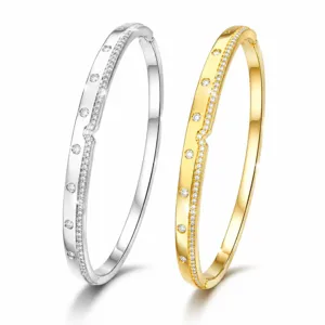 Exquisite paved gemstone bangles featuring elegant asymmetric wave design in gold and silver finishes.