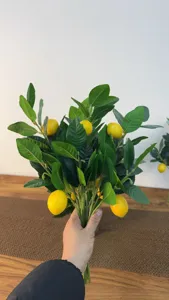 Handgehouden bos realistische kunstmatige citroentakken met groene bladeren en fruit