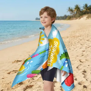 Junge trägt ein schnelltrocknendes Mikrofaser-Strandtuch mit Cartoon-Schwimm-Motiv