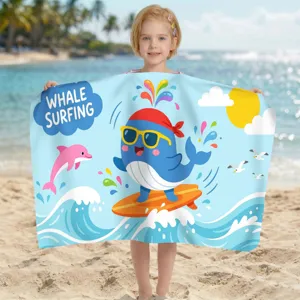 Kind hält Mikrofaser-Strandtuch mit süßem surfendem Wal-Cartoon am sonnigen Strand