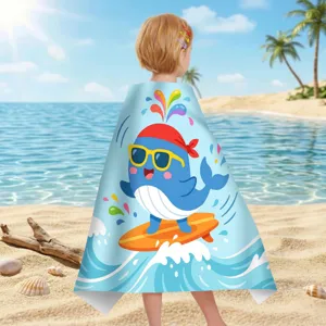 Rückansicht eines Kindes mit einem Mikrofaser-Strandtuch mit Wal-Motiv am sonnigen Strand