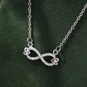 Detail view of a minimalist silver infinity symbol necklace sparkling with cubic zirconia stones.