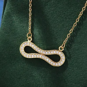 Close-up shot of a gold-plated infinity pendant necklace sparkling with cubic zirconia.