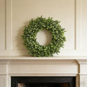 High-quality detailed view of the artificial boxwood wreath placed on a fireplace mantel