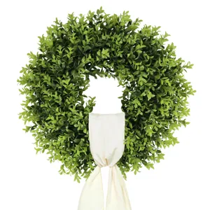 Frondosa corona de boj artificial con elegante lazo de cinta crema para la puerta