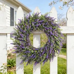 Vibrant purple lavender wreath hanging on a classic white wooden picket fence in a sunny garden.