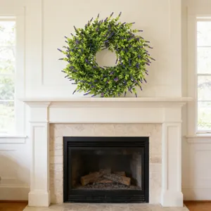 Beautiful artificial lavender and boxwood wreath hanging above a white fireplace mantel
