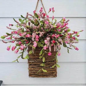 Detail of artificial pink flowers in a rustic woven hanging basket for spring wall decor