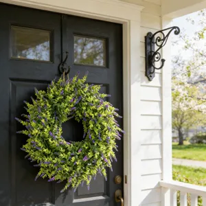 Lifelike artificial lavender and boxwood wreath hanging on a classic black front door