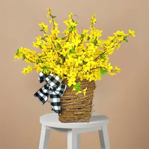 Detailansicht gelber Kunstblumen in einem Weidenkorb mit karierter Schleife