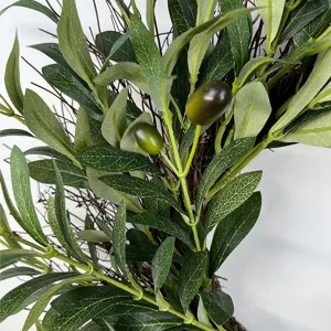 Close-up detail of realistic artificial olive leaves and fruit on a twig wreath.