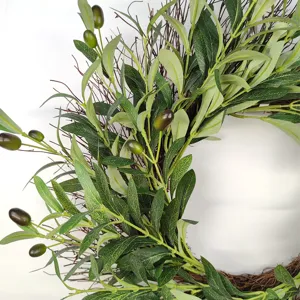 Detailed close-up of artificial olive leaves and green fruits on rustic twig wreath