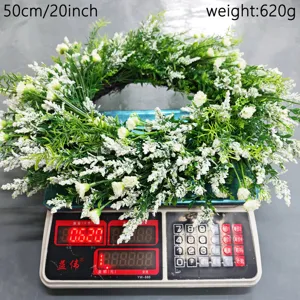 Detail view of a lush white floral wreath being measured on a scale showing 620g weight.