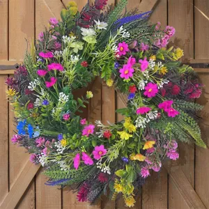 Levendige lente-zomer wilde bloemenkrans met madeliefjes op een rustieke houten schuurdeur