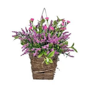 Vue détaillée de fleurs sauvages roses et de baies dans un panier en osier suspendu
