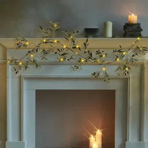 Close-up of 180cm artificial olive garland with warm LED lights decorating a mantlepiece